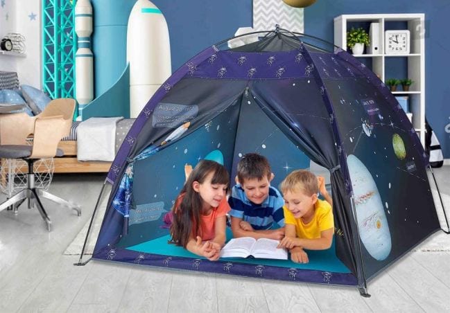 Three kids playing in a space themed tent in the living room