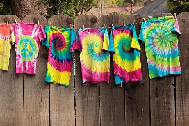 Row of tie dyed shirts hanging on a fence (Spring Break Activities)