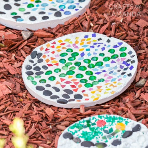 Round garden stepping stones decorated with glass beads as an example of summer crafts for kids