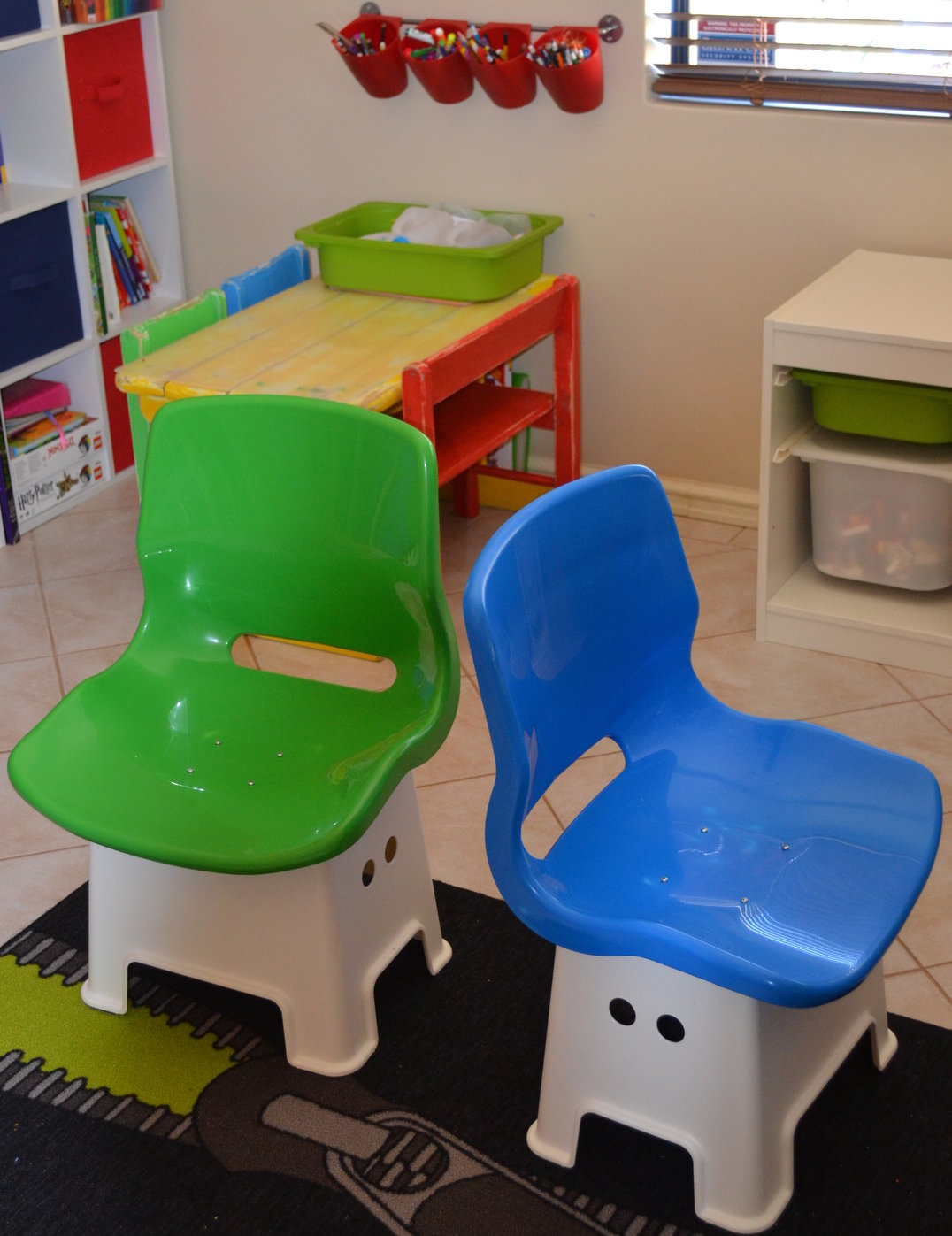 two white step stools have a blue and green seat attached to them to form a chair.
