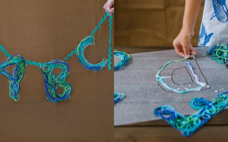 Blue and green letters created by dipping yarn in glue and laying it on wax paper