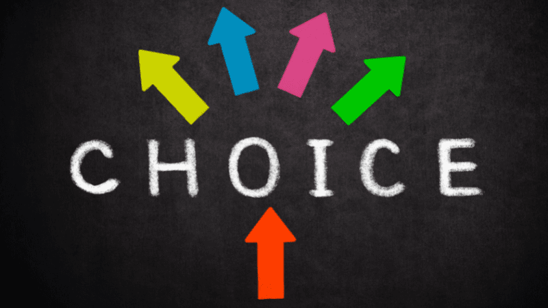Black background with the word "choice" written in the middle in white chalk font with colorful arrows pointing out in different directions from the word