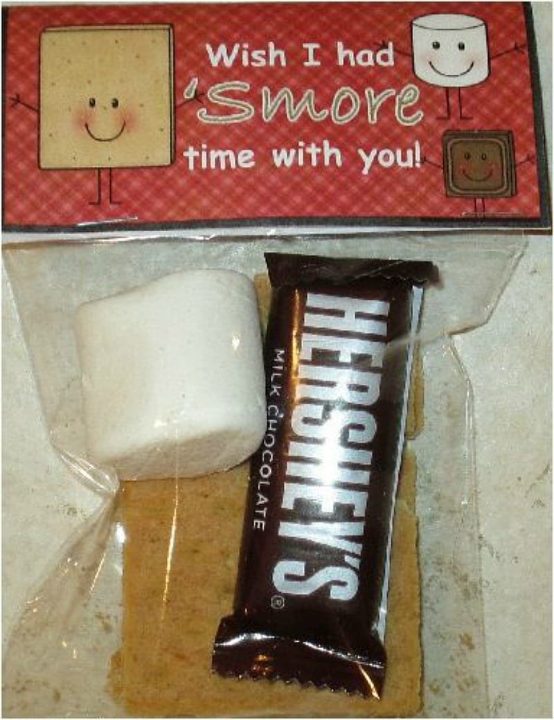 The ingredients to make s'mores packaged in a gift bag with a tag