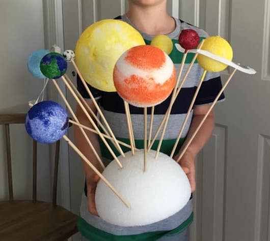 Styrofoam balls are painted to look like the sun and planets and are attached to a larger styrofoam base with skewers.