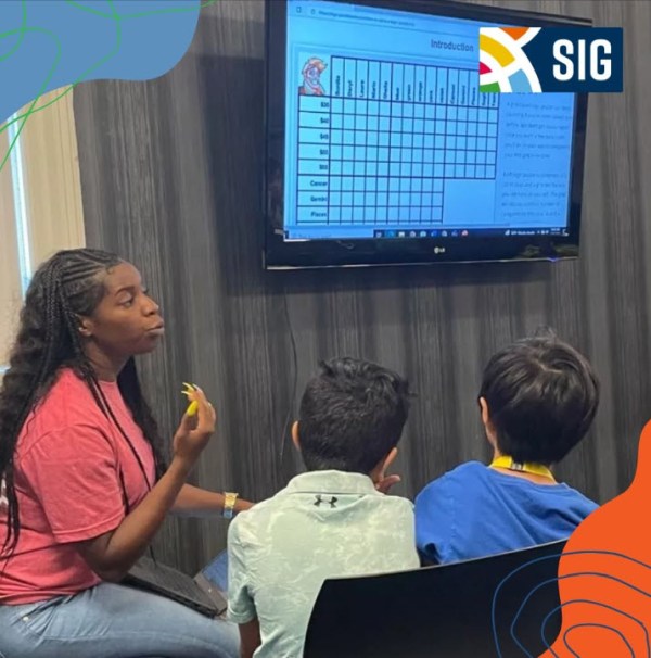 Teacher working with students at SIG summer camp (Summer Jobs for Teachers)