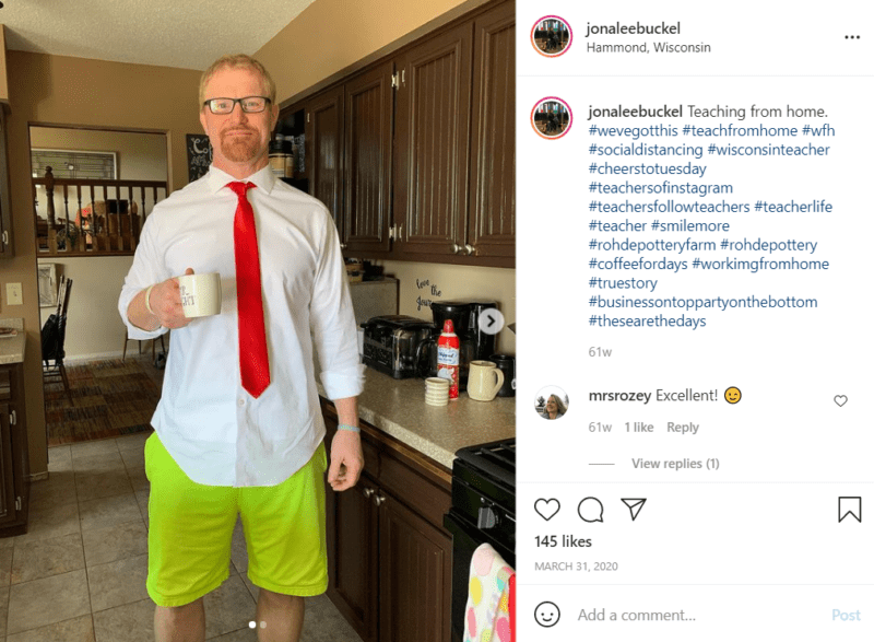 Teacher at home in his kitchen holding a mug and wearing bright green shorts along with shirt and tie