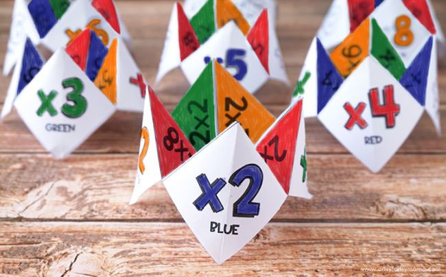 Colorful paper cootie catchers decorated with multiplication facts