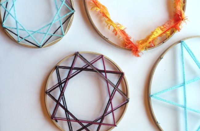 Embroidery hoops with yarn woven into patterns around them