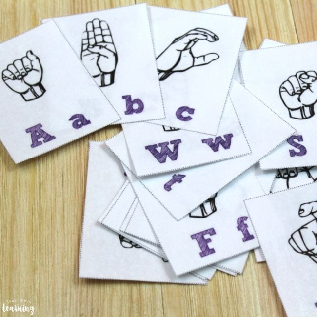 Black and white flashcards with alphabet letters and drawing of hands showing the signs for the letters