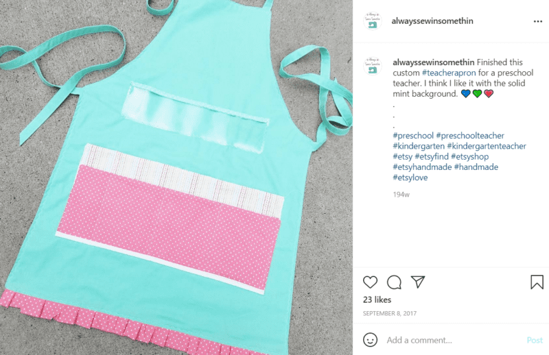 Teal apron with pink and white accents is laid out on the floor