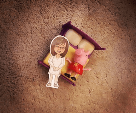 Flat Stanley teacher laid out against toy bed on carpet