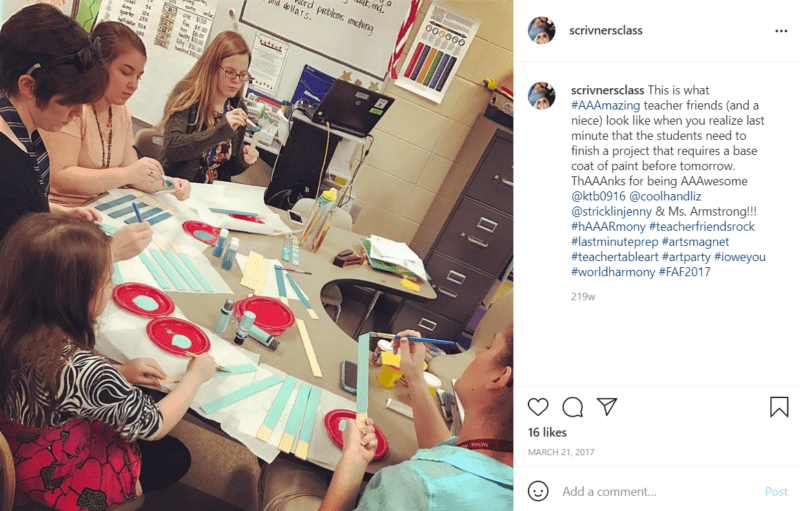 Teachers sitting at a table painting items for a student project