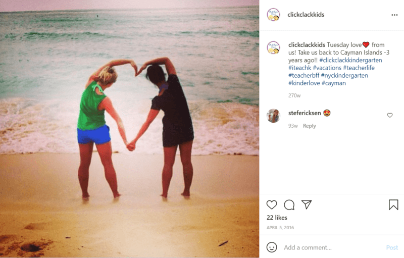 Two teachers posing with their arms to make a heart facing beach