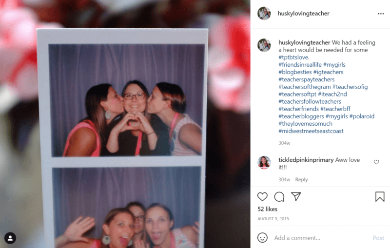 Three teachers in a photo booth kissing cheeks and making a heart with fingers
