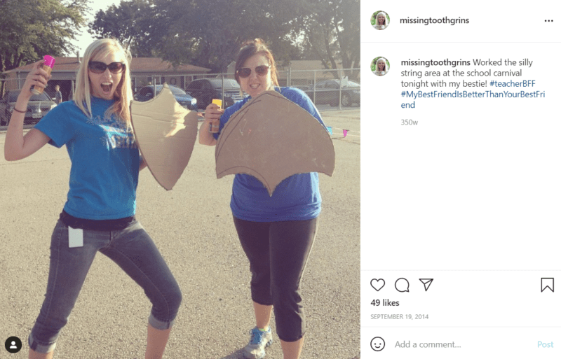 Two teachers post outside with shields made out of cardboard