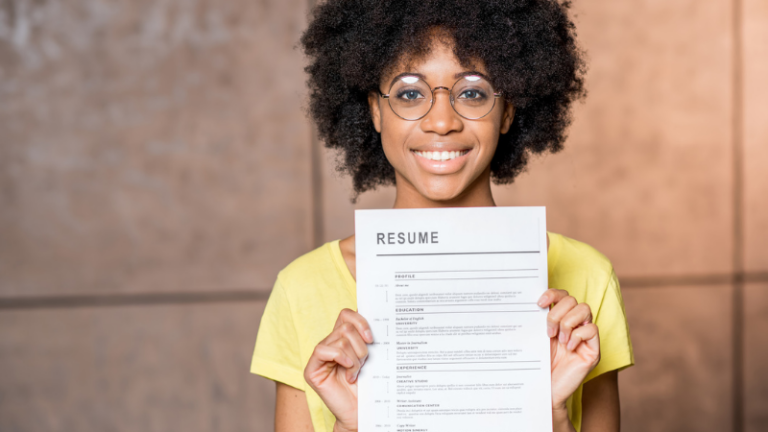 Closeup of woman holding up examples of her teacher resume.