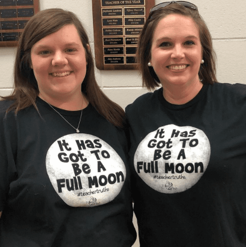 Two teachers in matching t-shirts.