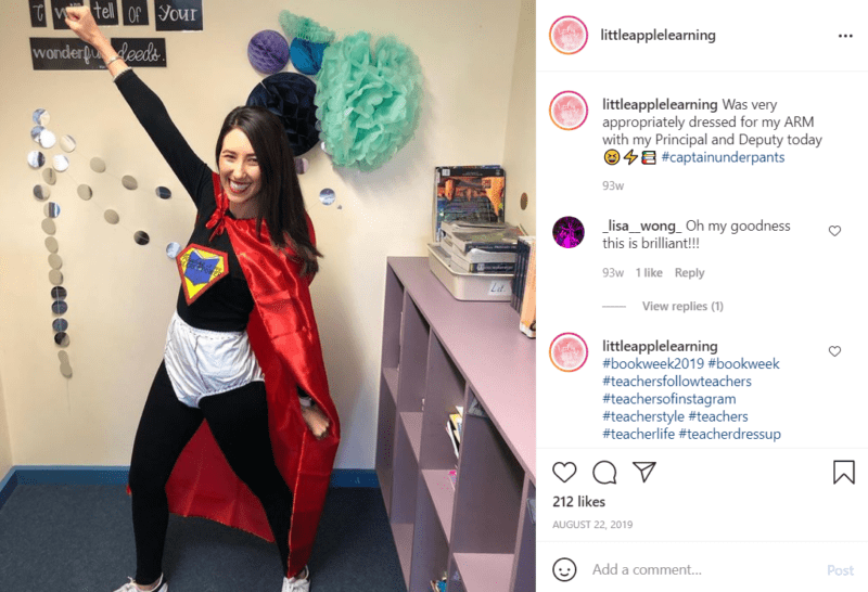 Teacher in a classroom striking a hero pose dressed as Captain Underpants