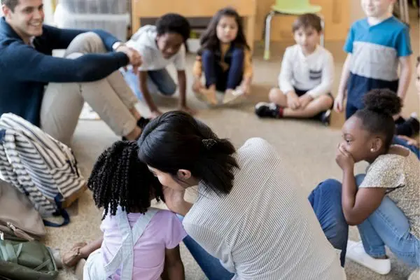 Young students playing the telephone game