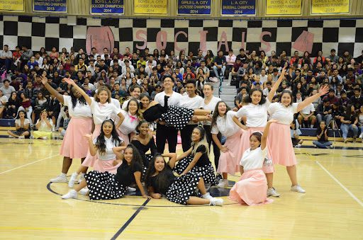 Students wearing 50s themed clothing smiling at the camera, as an example of pep rally activities and games