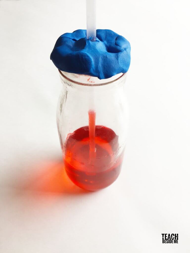 a DIY thermometer made from a glass with red liquid inside, a straw and blue play dough on top- weather activities
