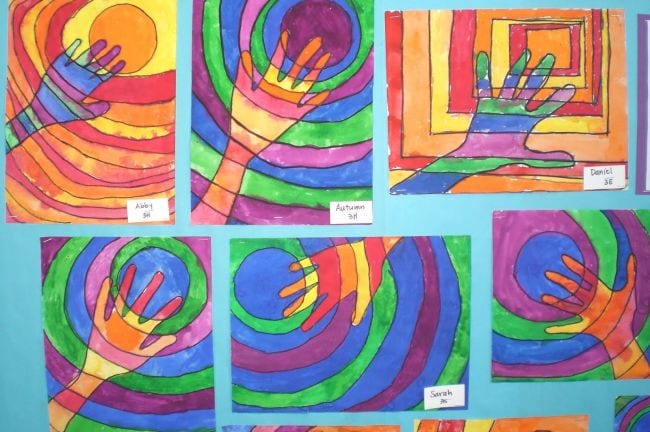 Third grade art projects include these drawings of hands with circles behind them in different colors.