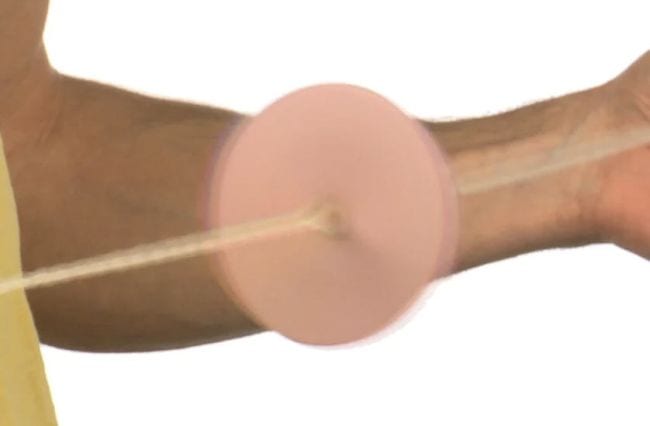 Spinning disk on a string, showing a beige color