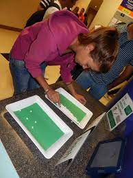 Pep rally activities include this one which shows a student trying to pick up a tic-tac with a pair of tweezers