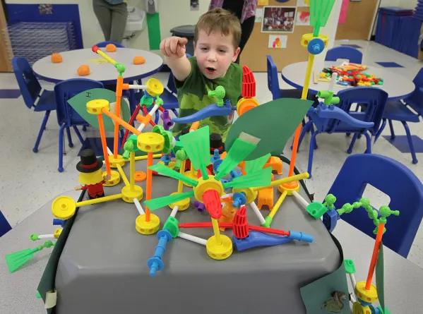 A child building with Tinkertoys