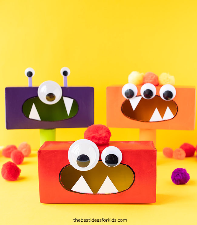 Three monsters are made from rectangular shaped tissue boxes that have been painted different colors. They have large googly eyes and teeth. Example of easy crafts for kids.