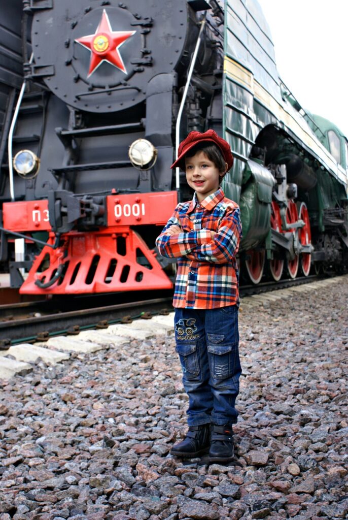boy standing outside a train engine