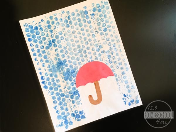Bubble wrap is painted blue with an umbrella in this example of kindergarten art projects