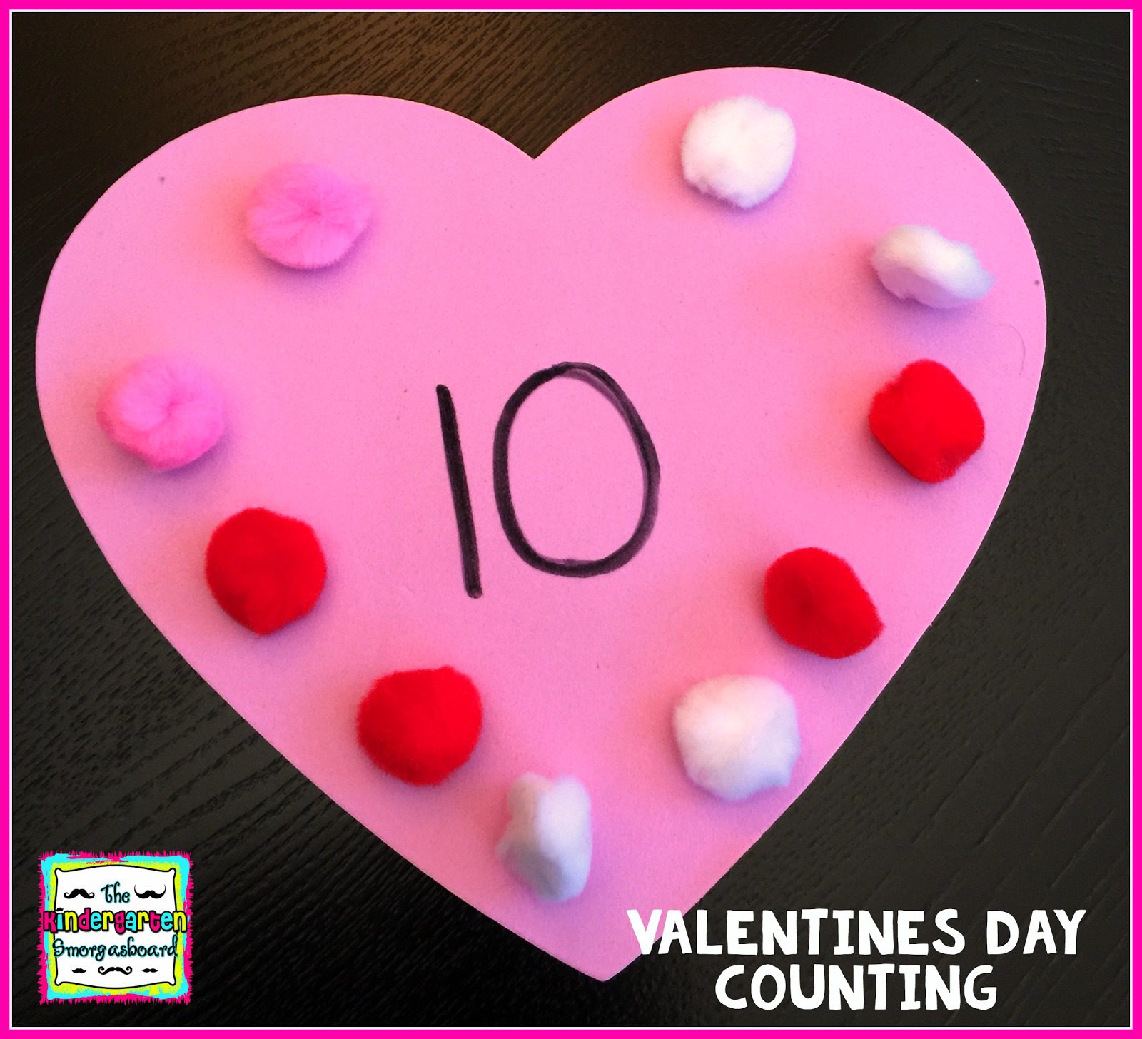 A pink heart has 10 red, pink, and white pom poms glued on it and it says 10 in the center (Valentine's Day Crafts for Preschoolers)