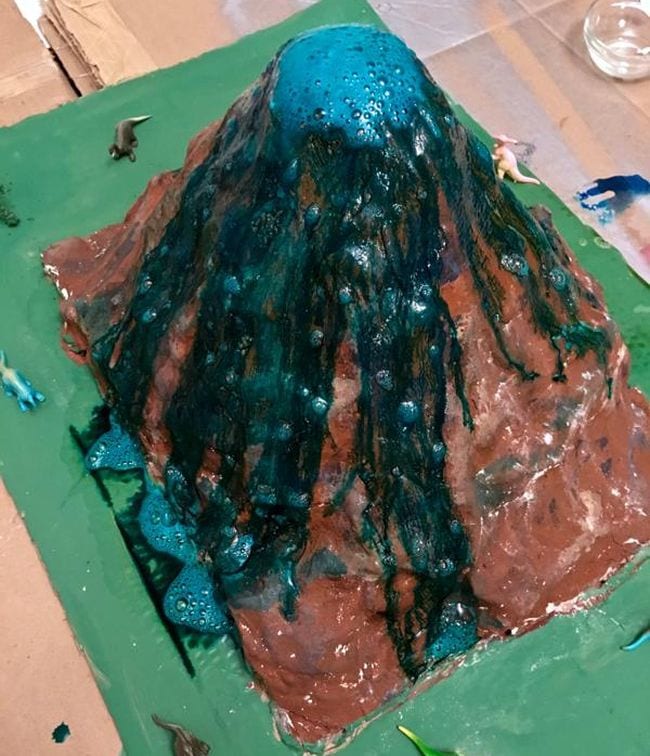 Papier-mâché model volcano erupting with blue lava