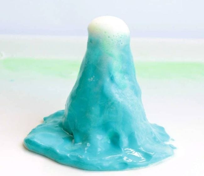 Model volcano made from blue playdough with white foam erupting (Volcano Science Experiments)