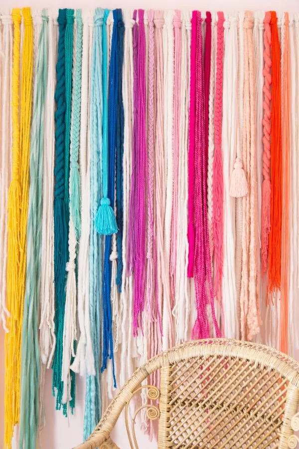 A colorful wall hanging made from individual strands of hand dyed yarn