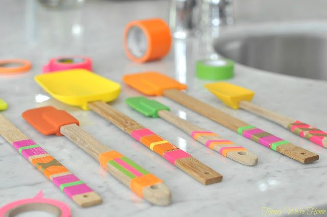 The handles of all different sized and colored spatulas have been decorated with different colored tape.