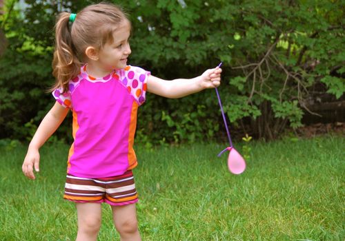 child holding a water balloon 