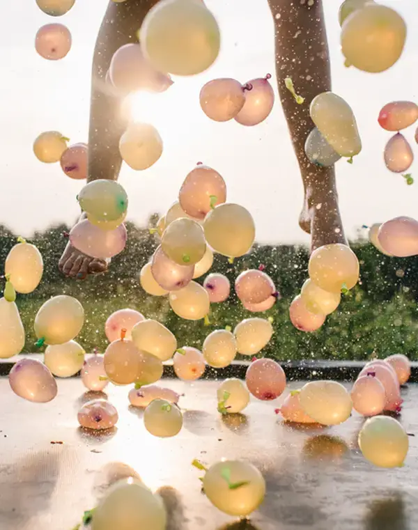 feet bouncing on a trampoline with water balloons