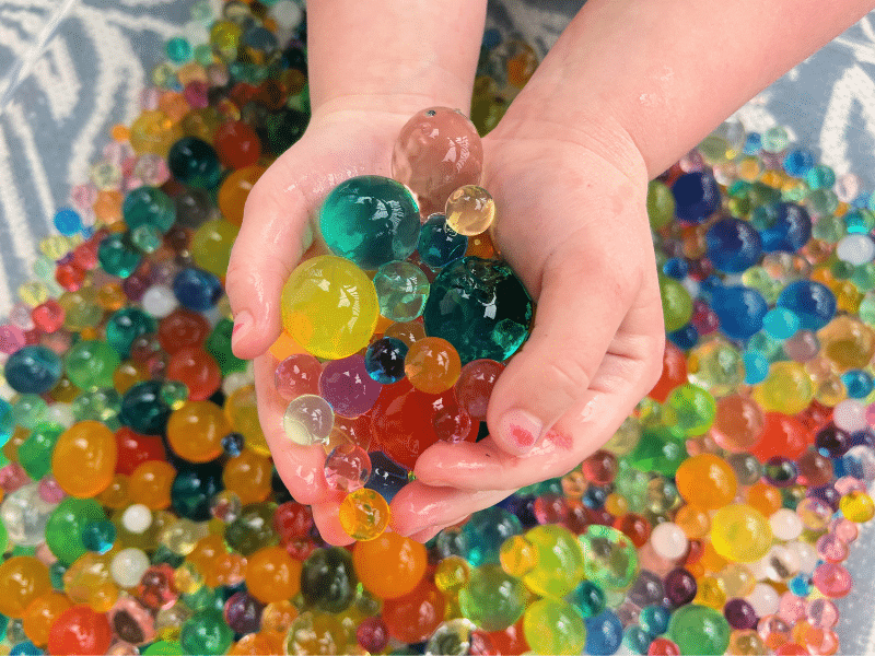 hands playing with water beads 
