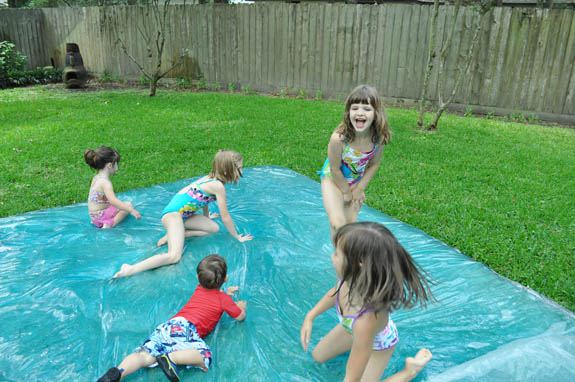 kids sitting on a water blob or big bag filled with water 