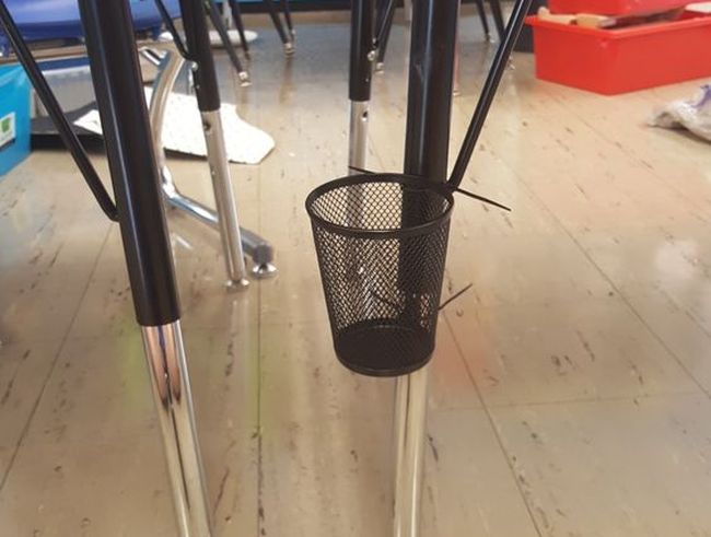 Mesh pencil cup attached to leg of student desk with zip ties
