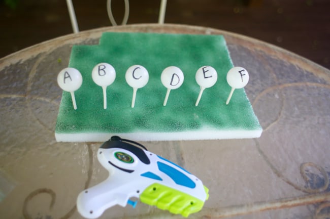 ping pong balls with letters and a squirt water gun 