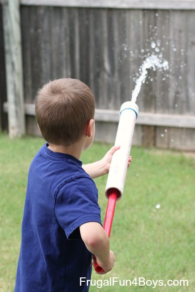 child holding water shooter made with PVC pipe 