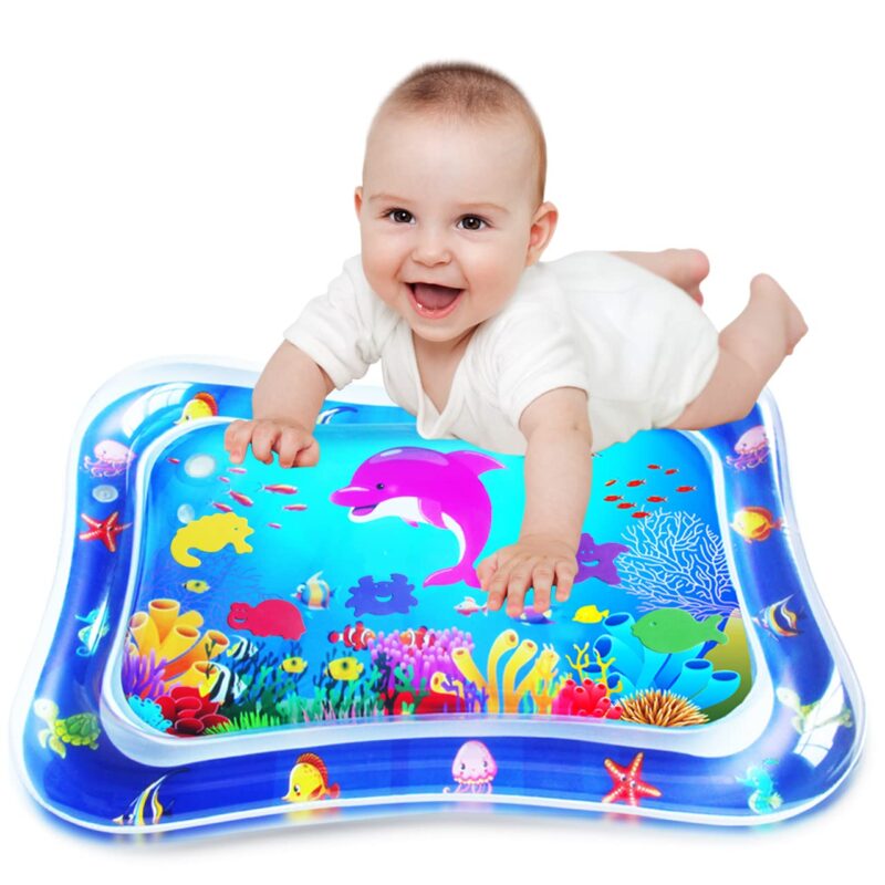A smiling baby lays on an inflatable mat with sea life designs on it (sensory toys)