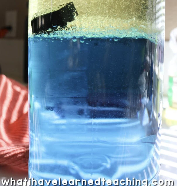 Plastic bottle with blue water and a toy ship inside