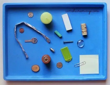 household objects on a tray, key, cork, paper, paperclip for an electricity experiment