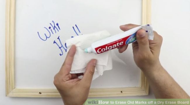 Teacher using toothpaste to clean marker off a whiteboard
