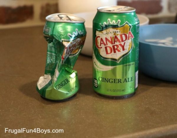 Two empty ginger ale cans, one crushed for a winter science experiment 