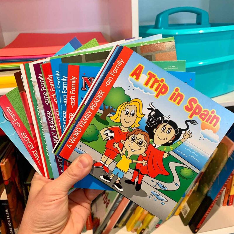 Hand holding a stack of word family readers dollar books from Oriental Trading